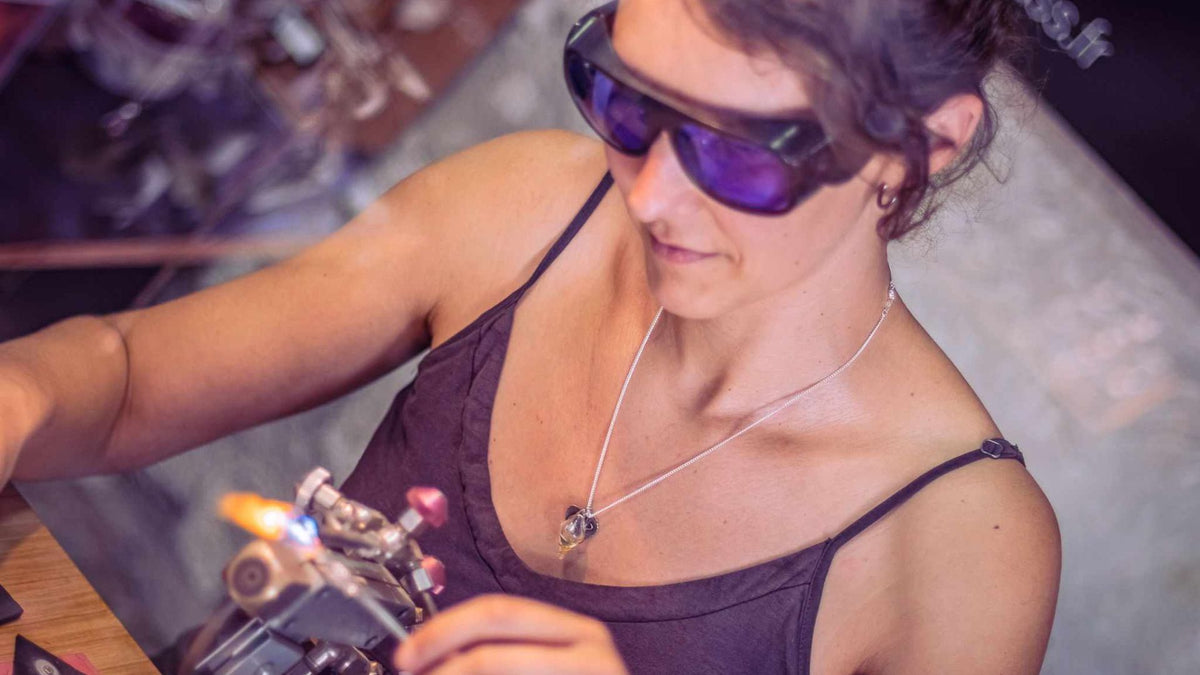 Céline façonne le verre au chalumeau dans son atelier