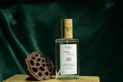 Flacon Lotus Sacré de Parfumens sur fond vert, avec une capsule de lotus séchée